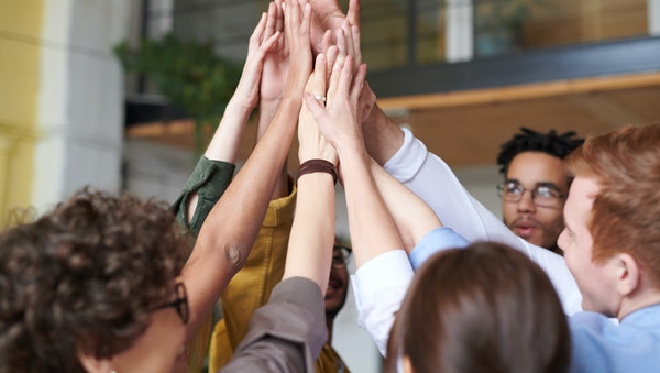 group of students touching hands and being spirited 