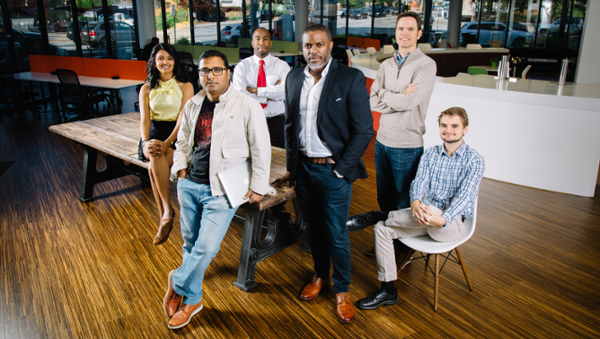 group of diverse people standing at table